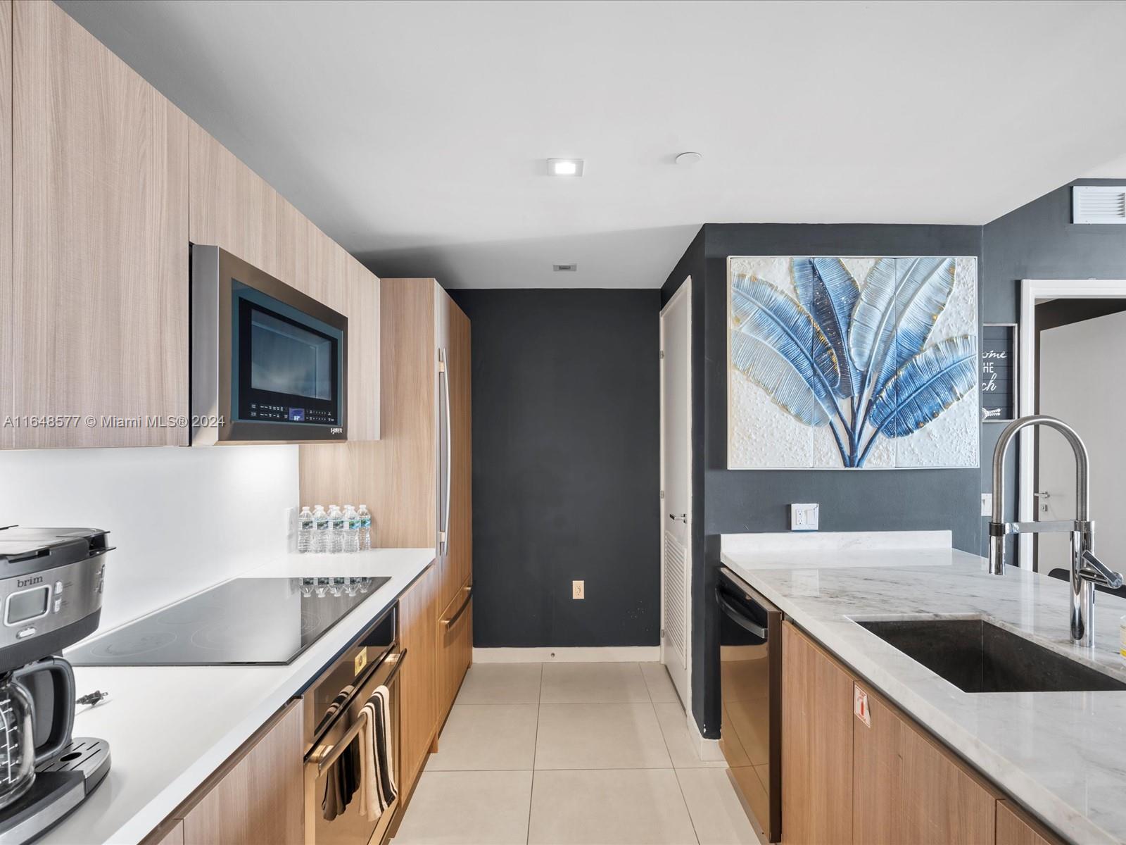 a kitchen with granite countertop a sink and a stove top oven