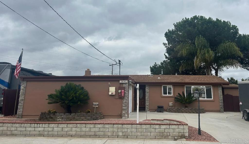 a front view of a house with a yard and potted plants