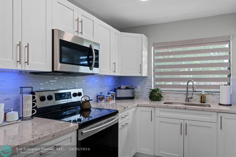 Fully remodeled eat-in kitchen features new stainless steel appliances, quartz countertops & large pantry