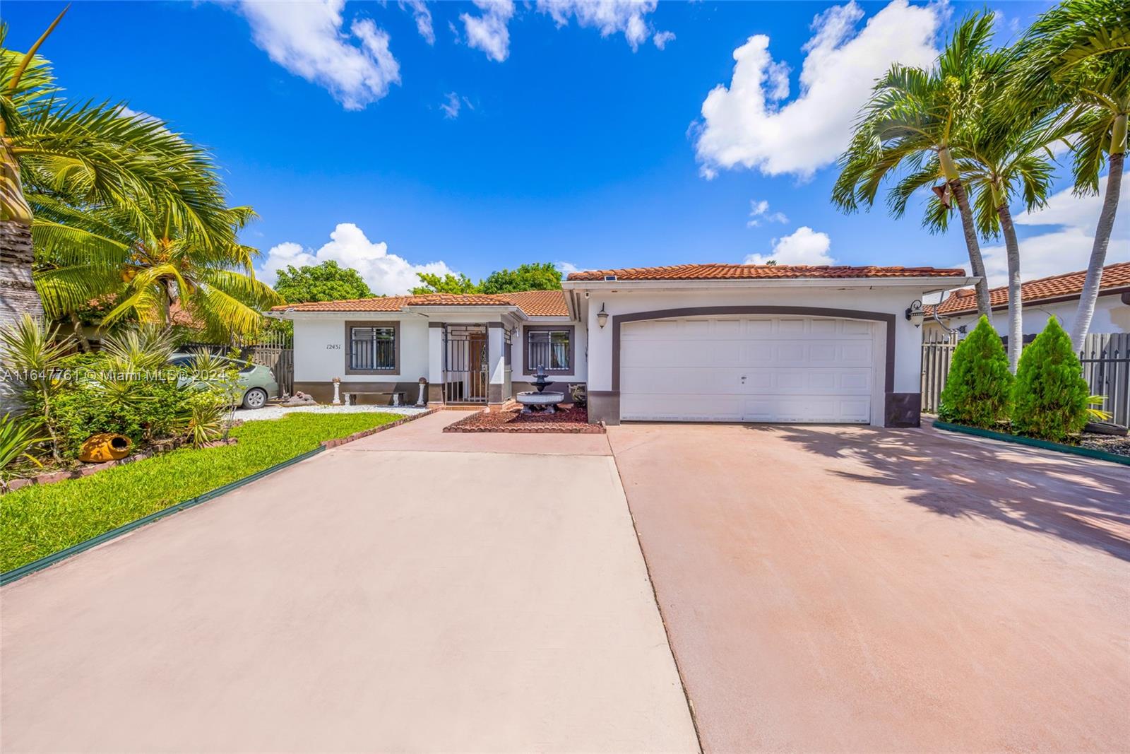 a front view of a house with a yard and palm trees