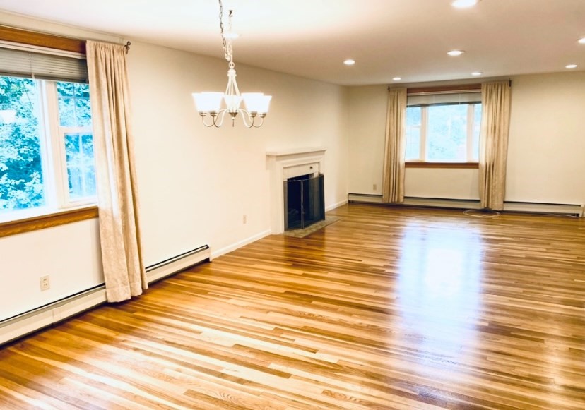 a view of a livingroom with a chandelier wooden floor and front door