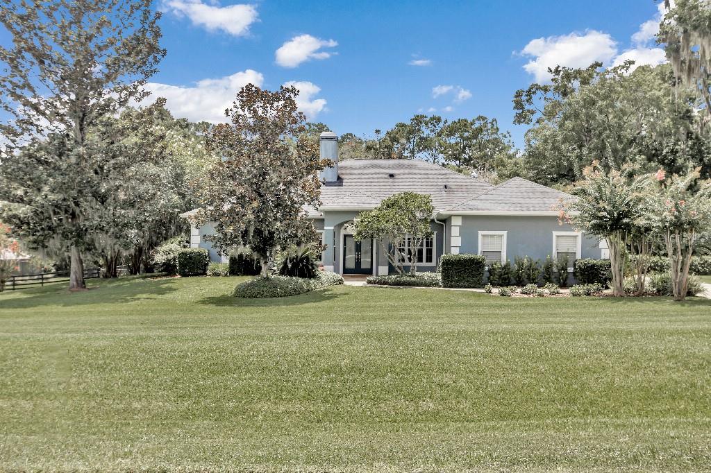 a front view of a house with a yard and trees