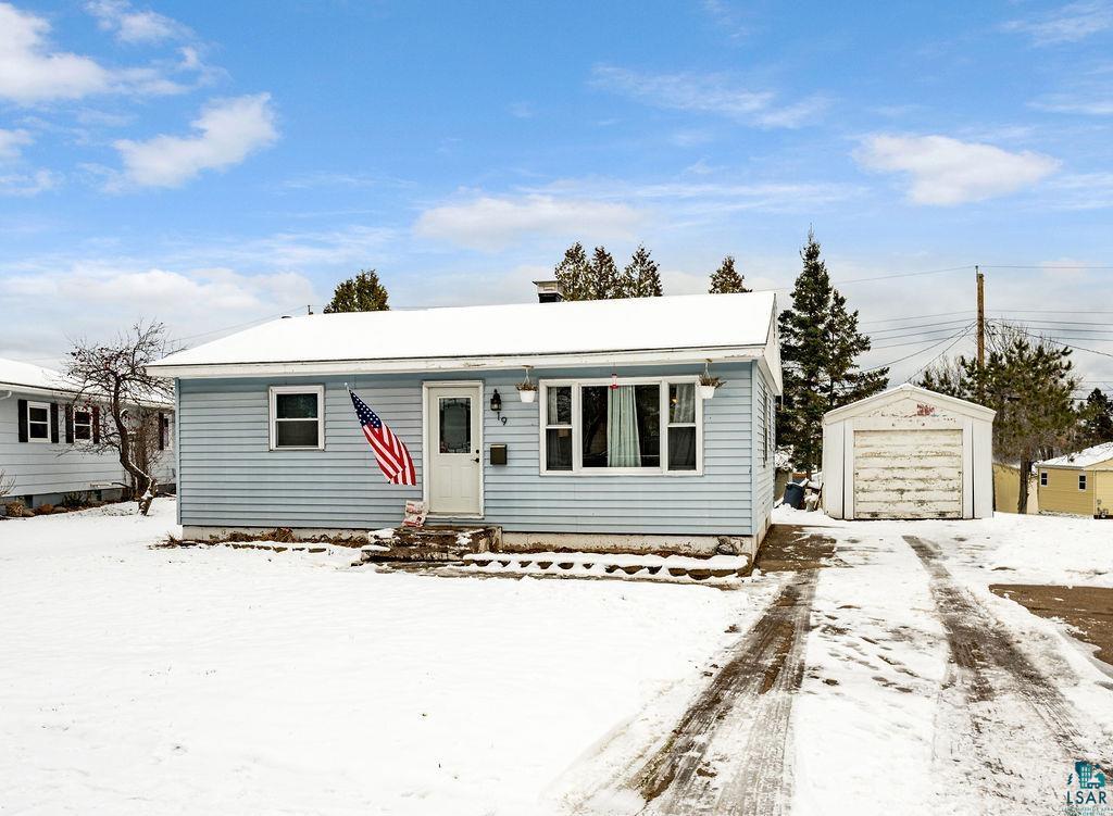 View of front facade featuring an outbuilding and a garage