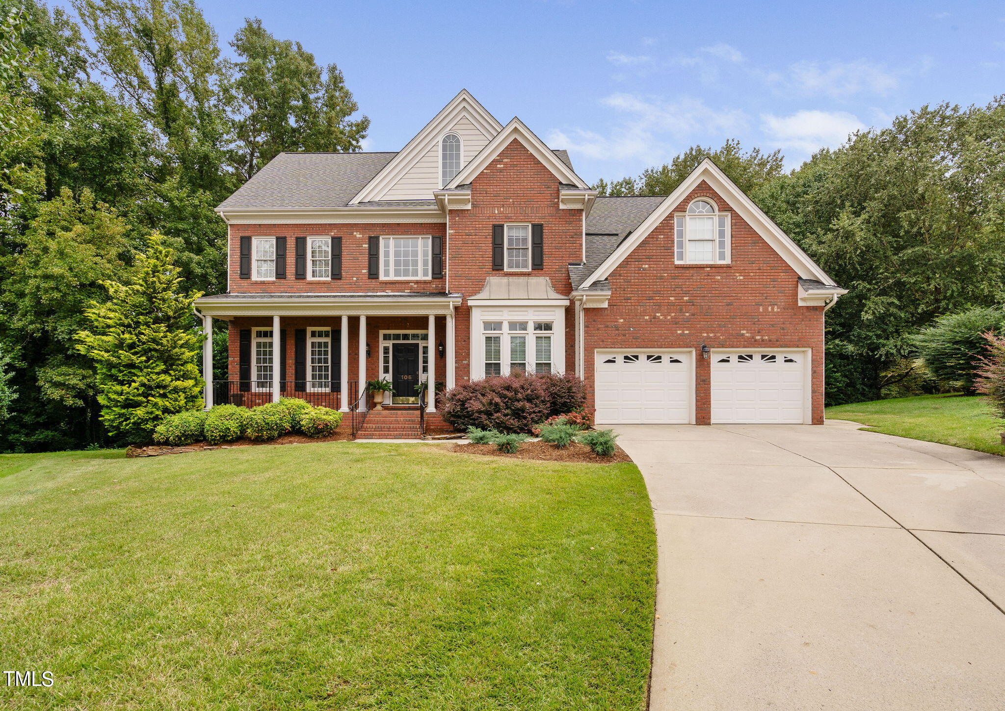 a front view of a house with yard and green space