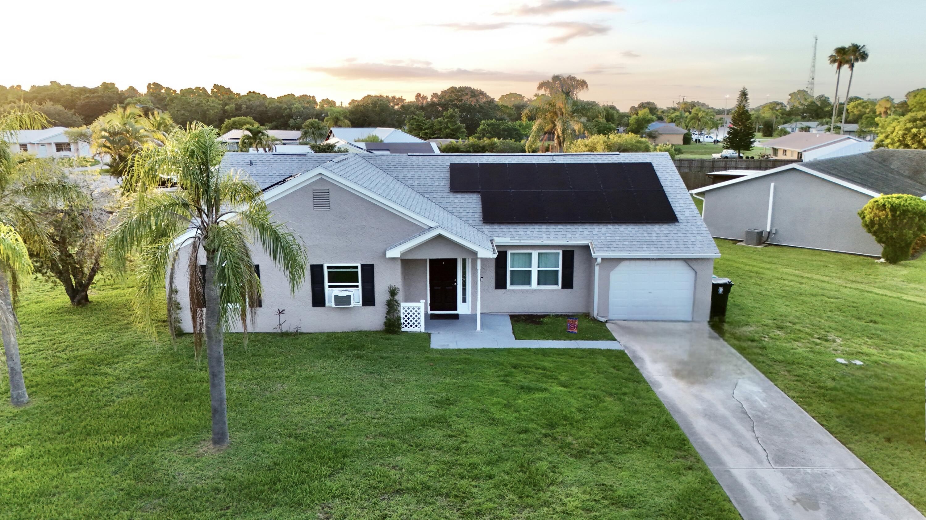 a aerial view of a house next to a big yard and large trees