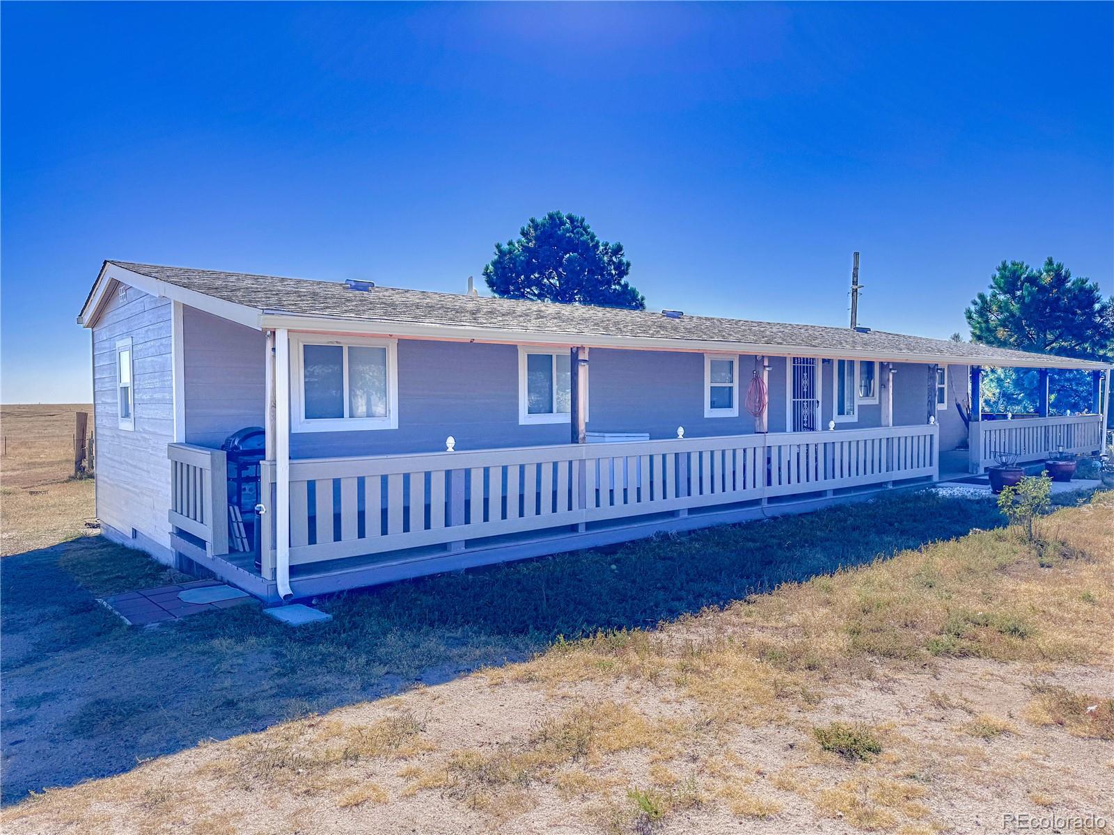 a view of a house with wooden deck and a yard