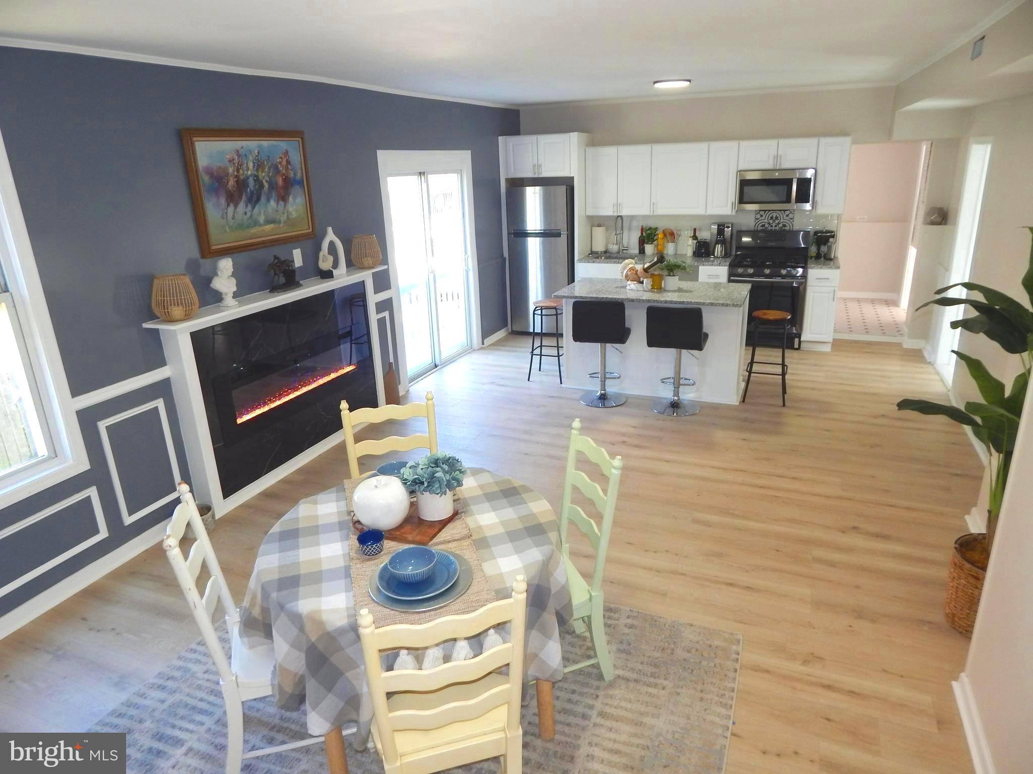 a living room with furniture a flat screen tv and kitchen view