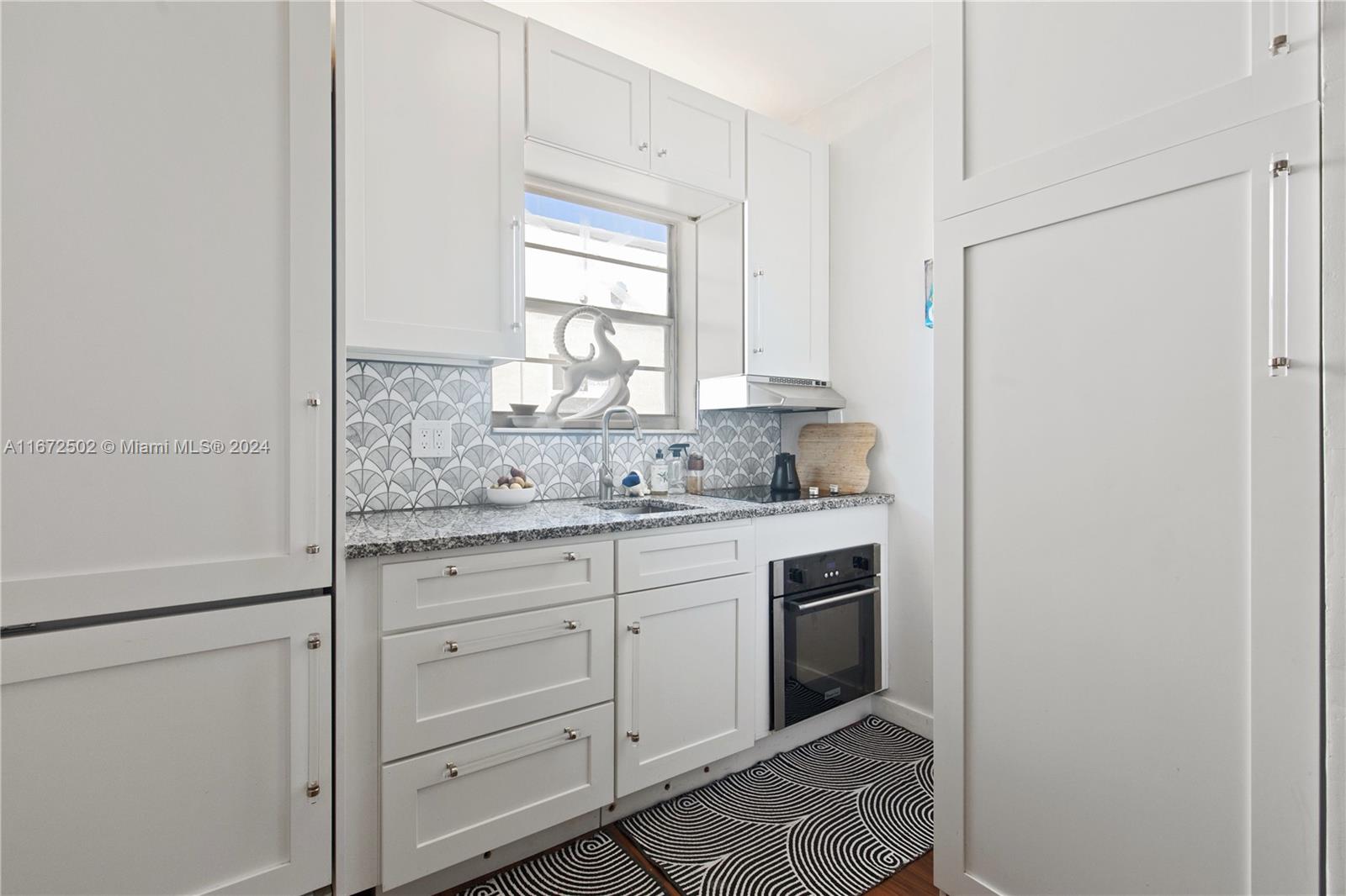 a bathroom with a granite countertop sink and a window