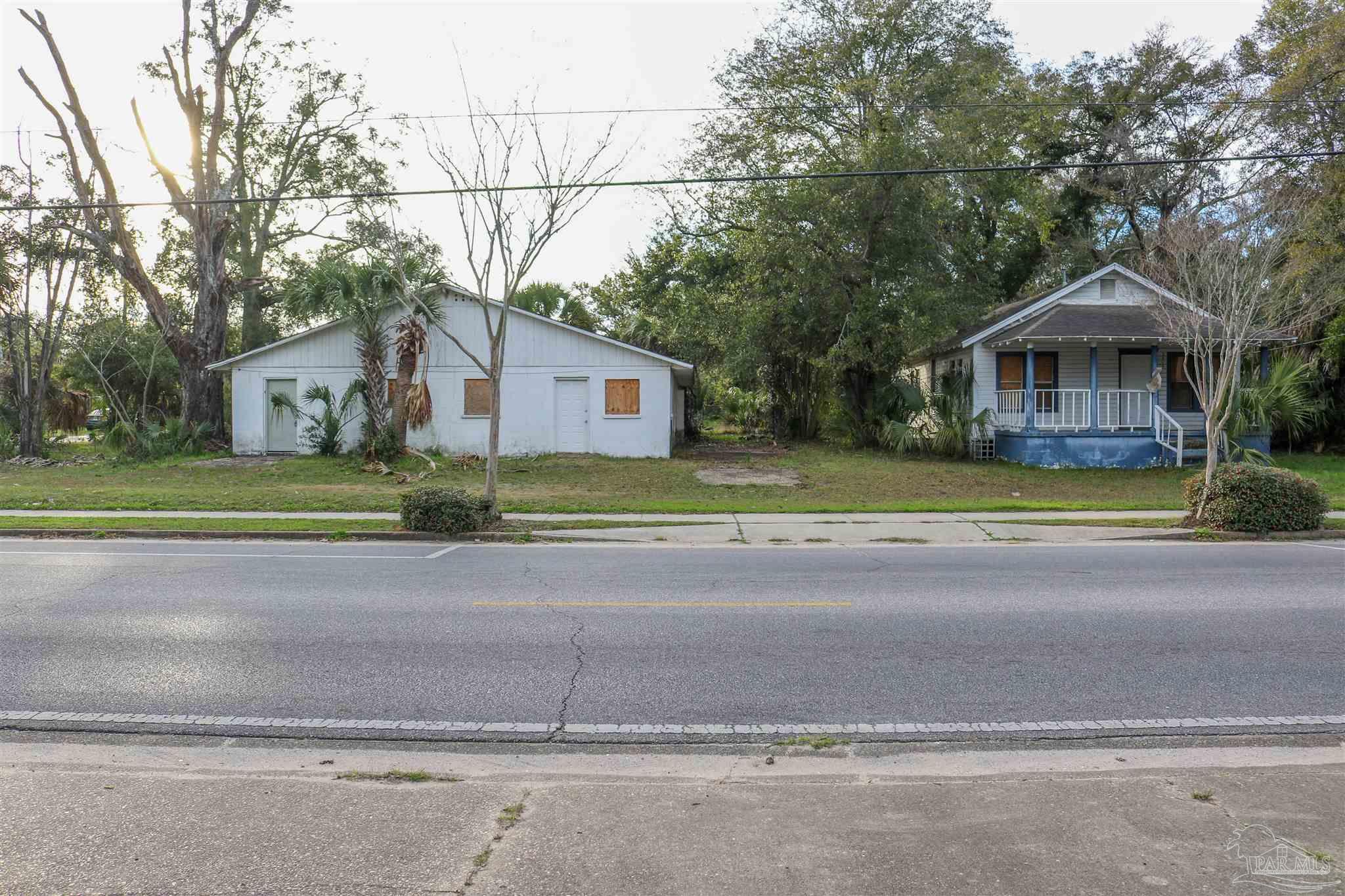 a front view of a house with a garden and trees