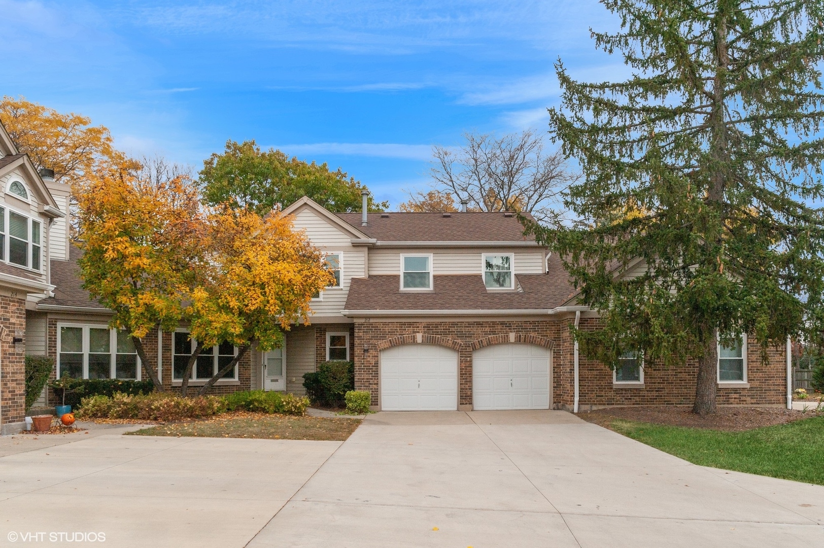 a front view of a house with a garden and tree