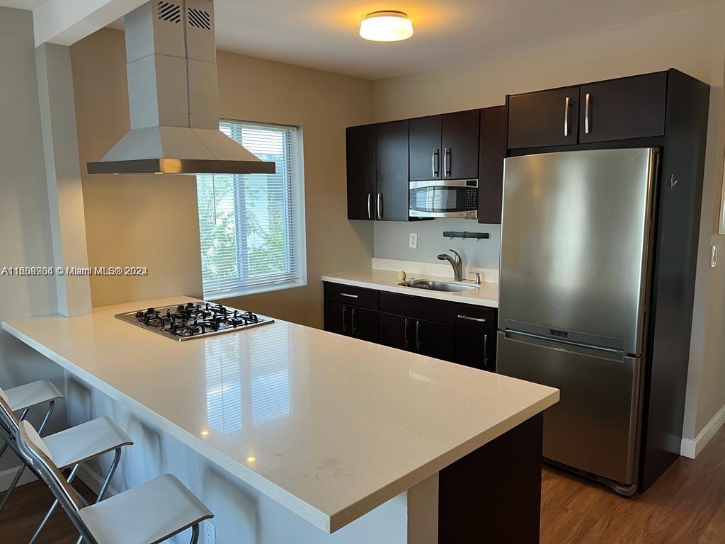 a kitchen with a sink a stove a refrigerator and a oven