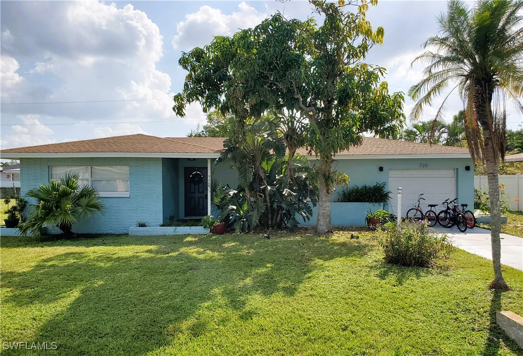 a view of a house with a yard and potted plants