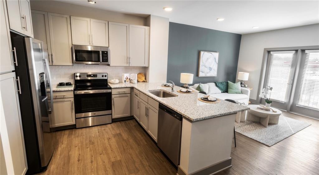 a kitchen with a sink appliances and wooden floor