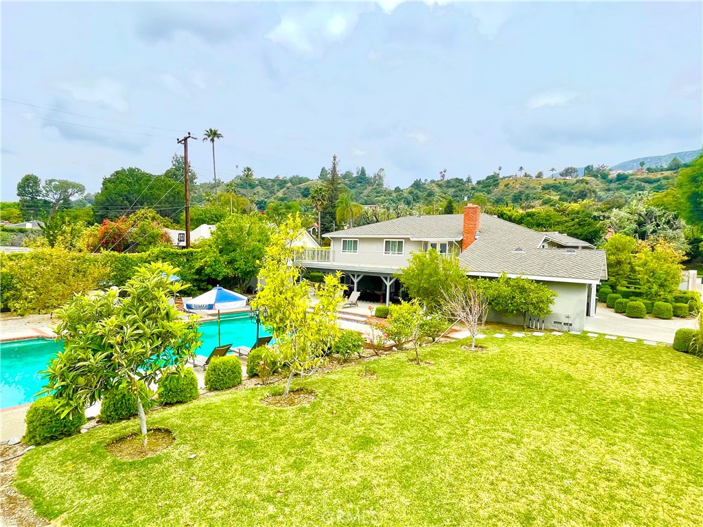 a view of a big yard with an ocean and houses in the background