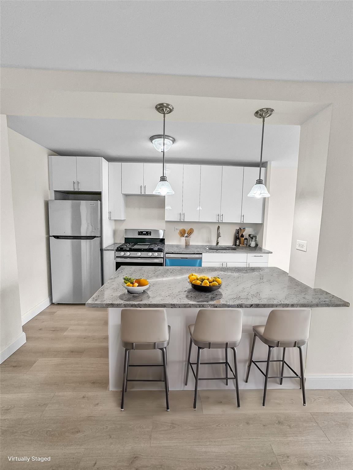 Kitchen featuring pendant lighting, sink, white cabinets, and stainless steel appliances