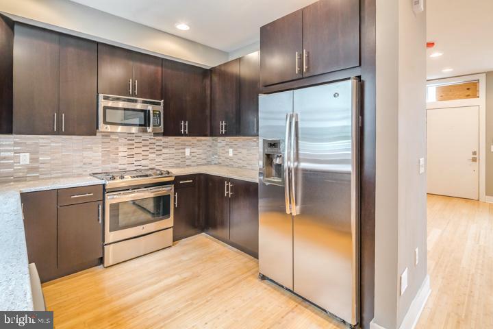 a kitchen with kitchen island granite countertop stainless steel appliances and sink