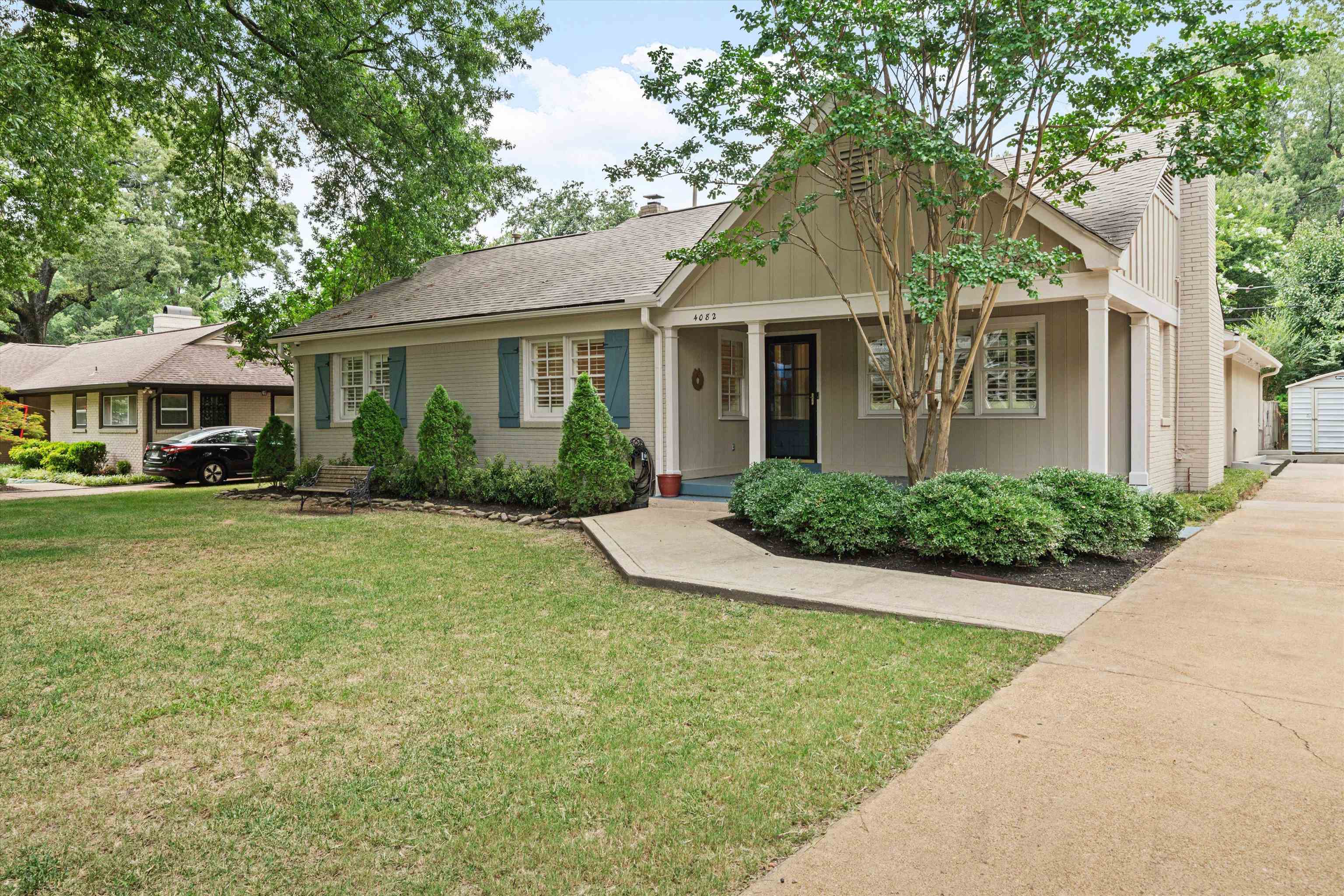 View of front of property featuring a garage, an outdoor structure, and a front yard