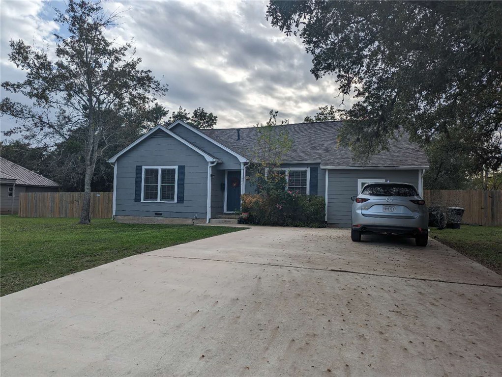 a car parked in front of a house with a yard