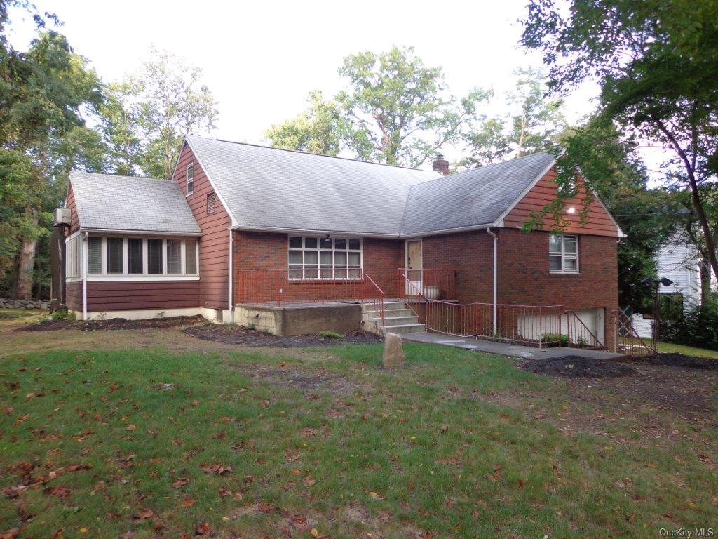 a front view of a house with a garden and trees