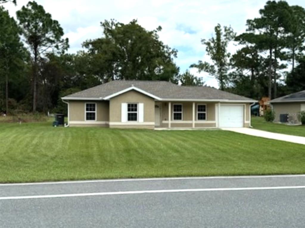 a view of a yard in front of a house with a large tree