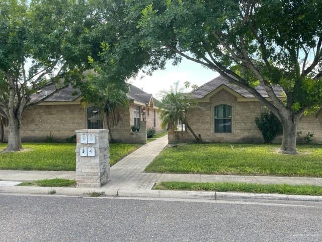 a front view of a house with a yard and tree s