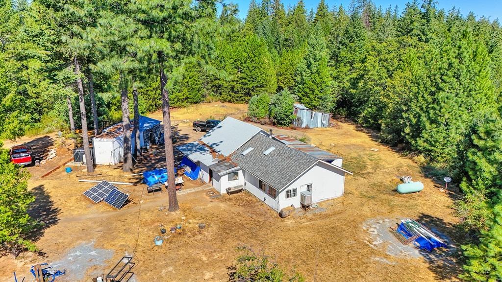 an aerial view of a house with swimming pool and large trees