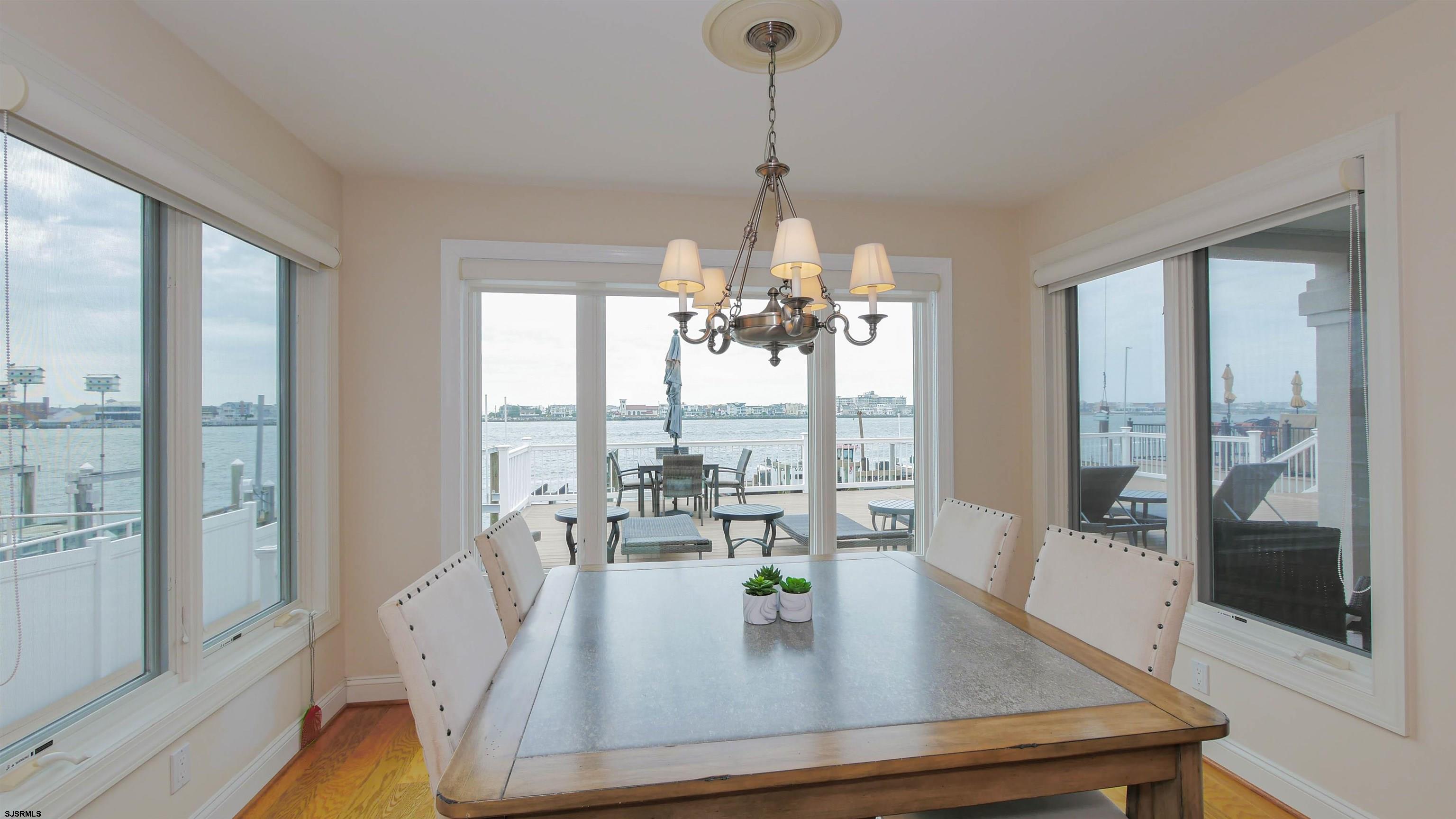 a dining room with furniture a chandelier and wooden floor