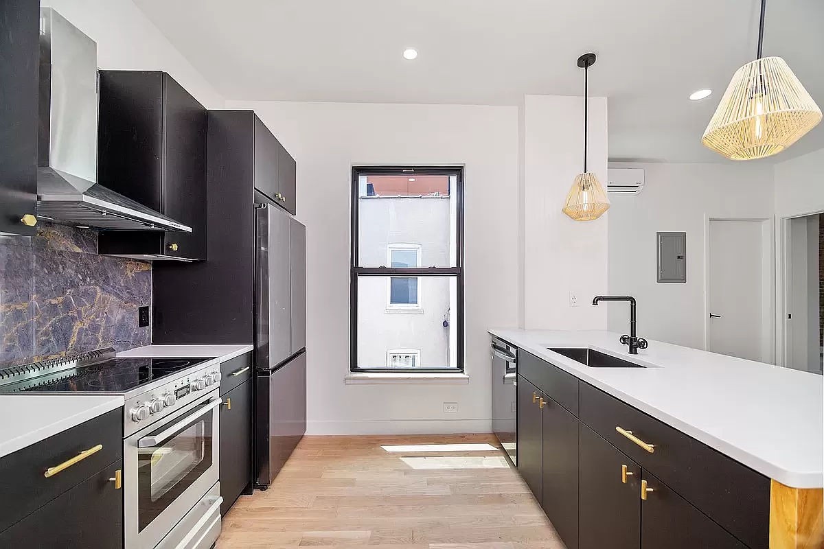 a kitchen with stainless steel appliances granite countertop a sink a stove and a refrigerator