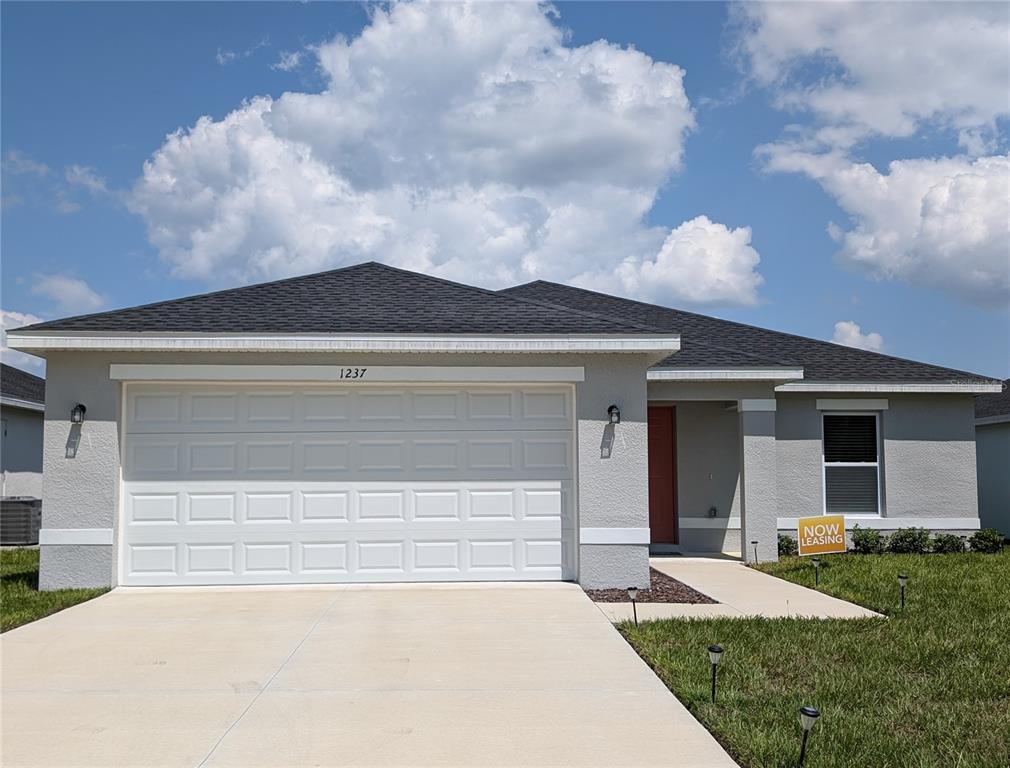 a front view of a house with a yard and garage