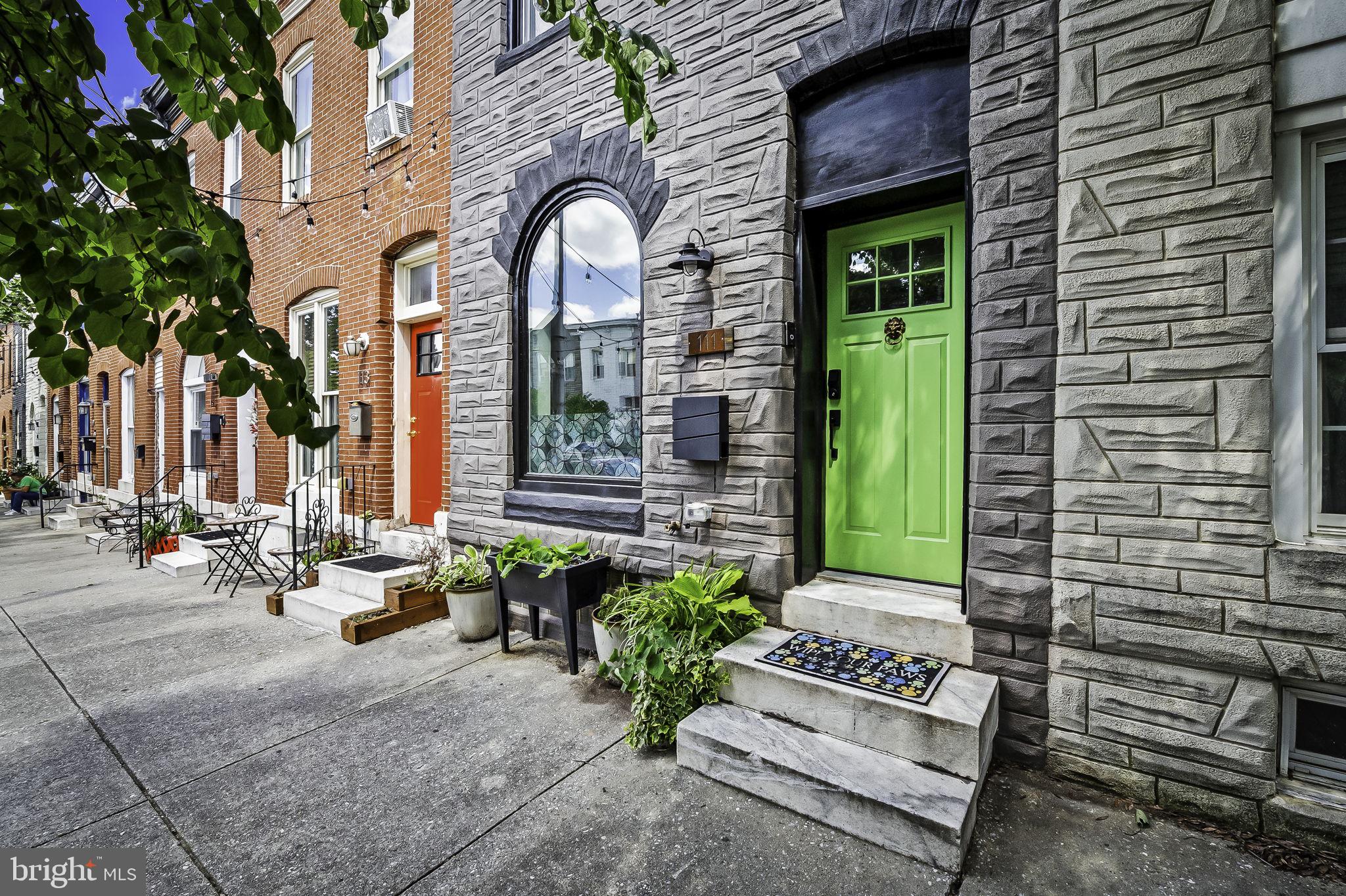 a view of a brick house with potted plants and a bench