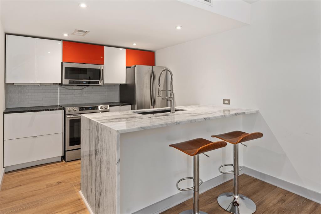 a kitchen with stainless steel appliances granite countertop a sink and a microwave