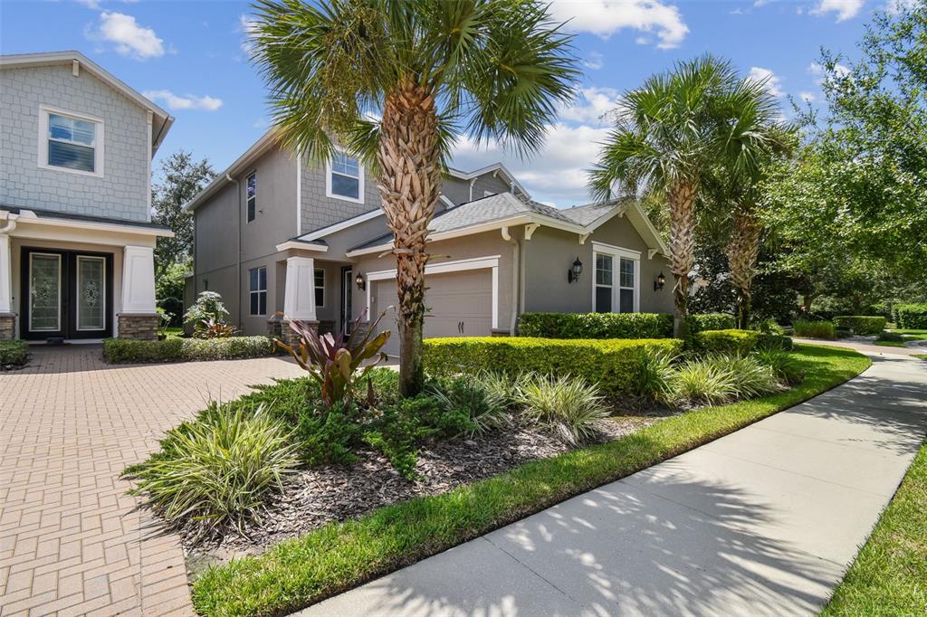 a front view of a house with a yard and potted plants