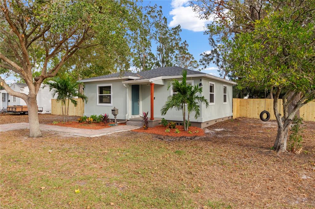 a view of a house with backyard and tree