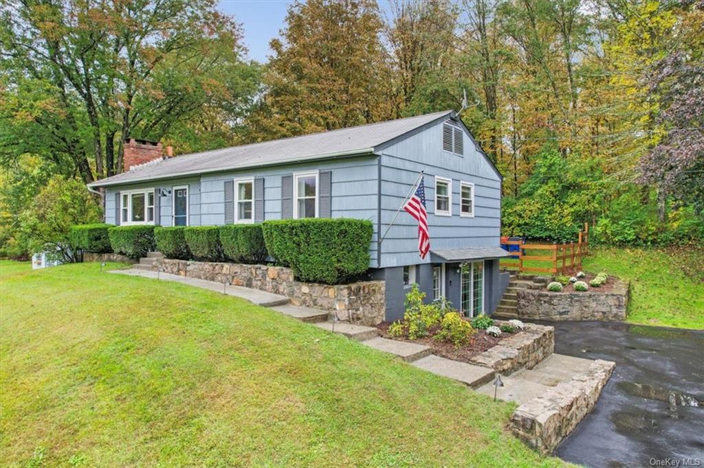 View of front of house with a walk out lower level to the oversized driveway.