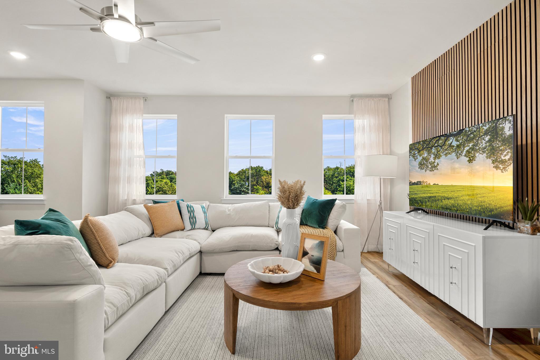 a living room with furniture a flat screen tv and a large window