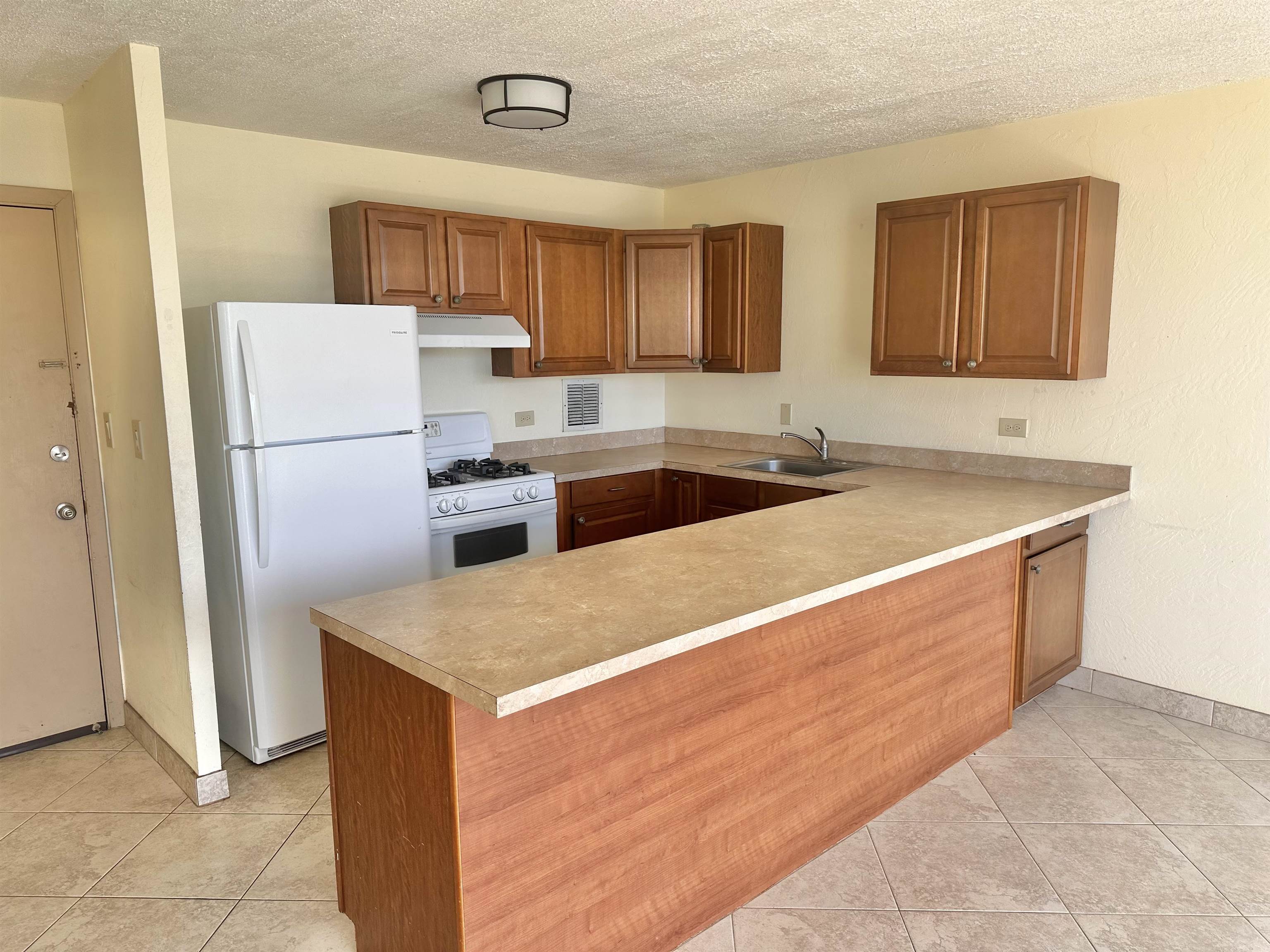 a kitchen with stainless steel appliances granite countertop a refrigerator sink and white cabinets