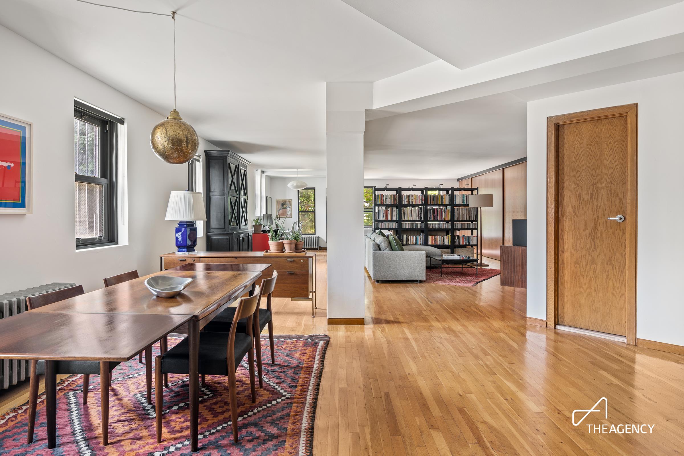 a view of a dining room and livingroom with furniture wooden floor a chandelier