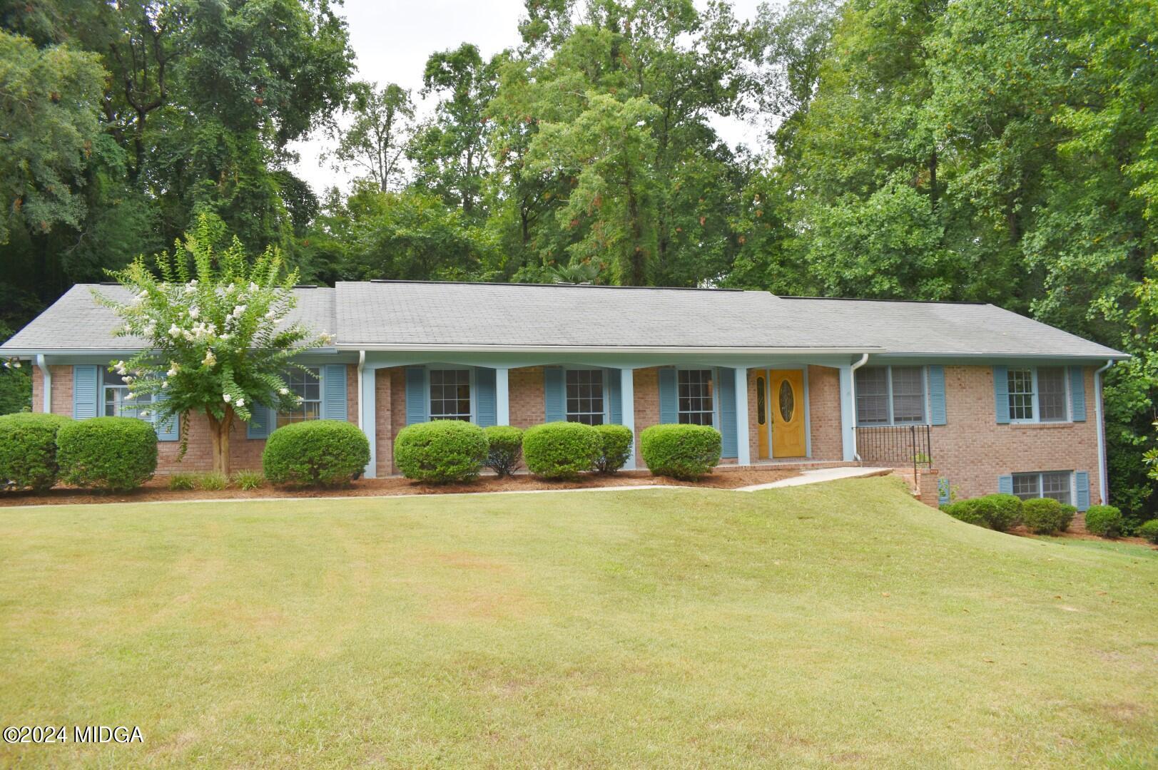 a front view of a house with a yard and potted plants