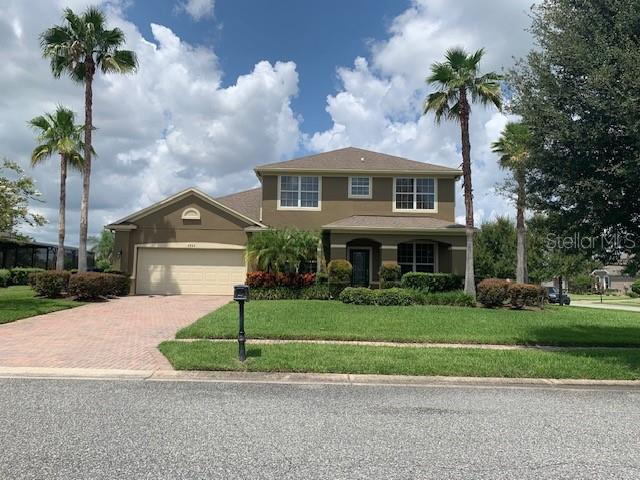 a front view of a house with a garden and palm trees