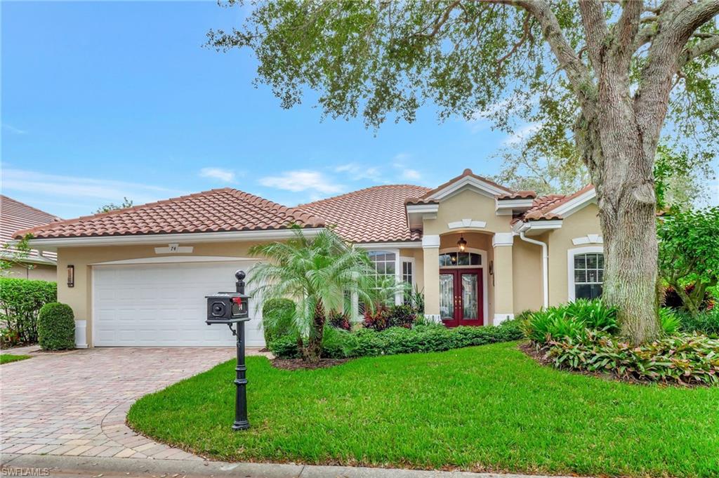 Mediterranean / spanish home with a front yard, french doors, and a garage