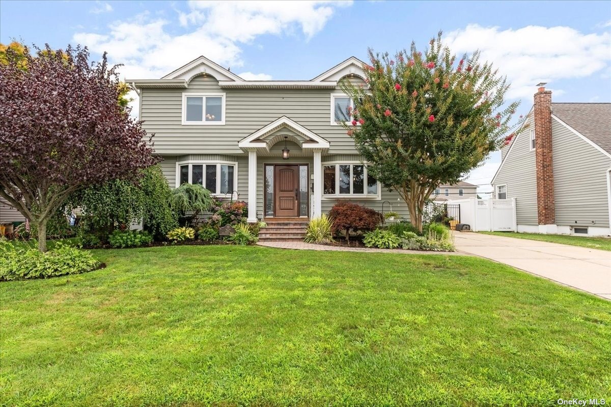 a front view of a house with a yard and trees