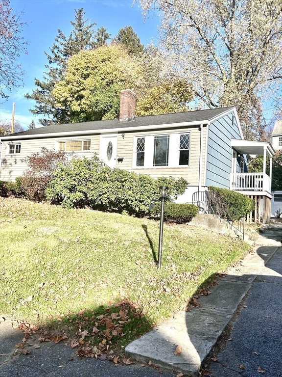 a front view of a house with a yard and ocean view