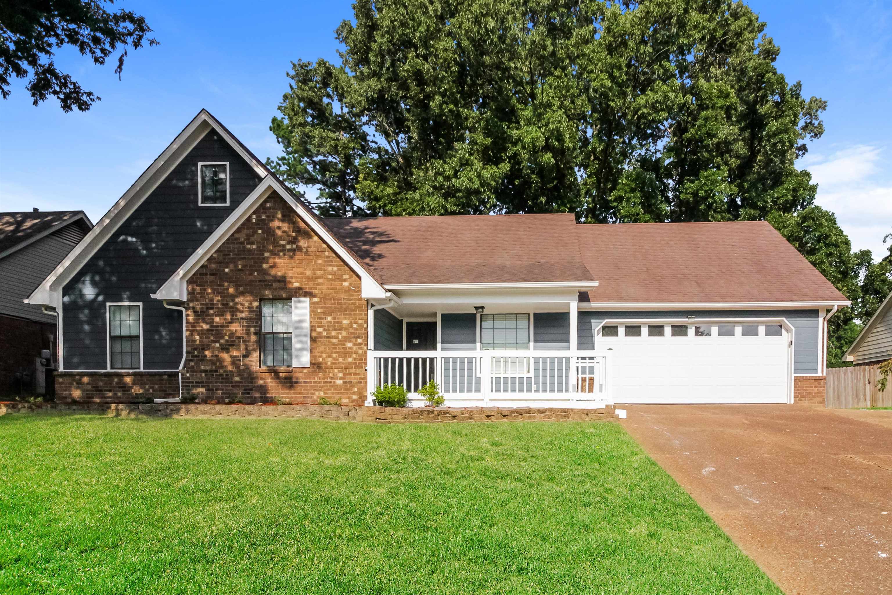 View of front of home featuring a garage, a front yard, and a porch