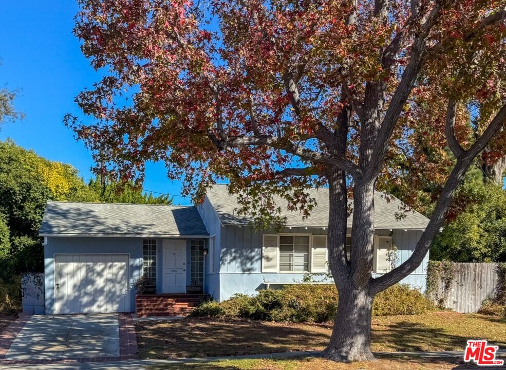 a front view of a house with a tree