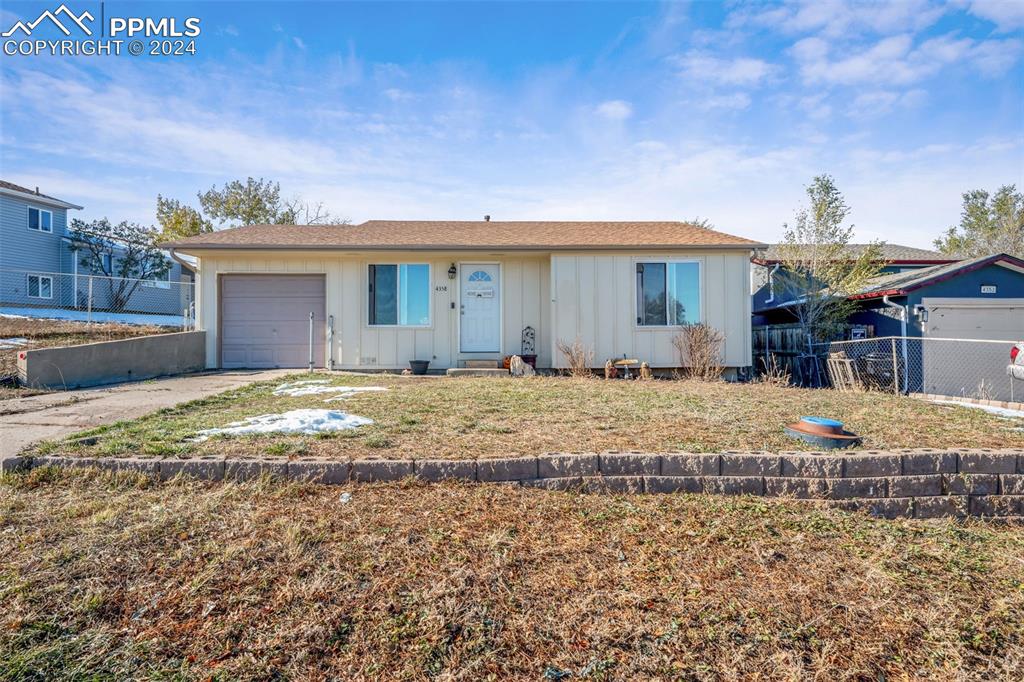 Single story home with a garage and a front yard