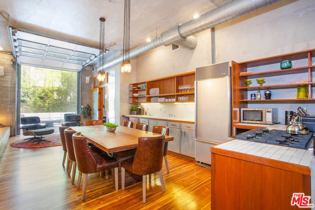 a dining hall with stainless steel appliances granite countertop a stove and refrigerator