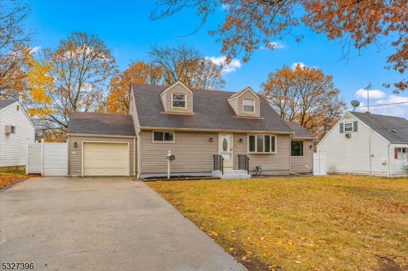 a front view of house with yard and trees in the background