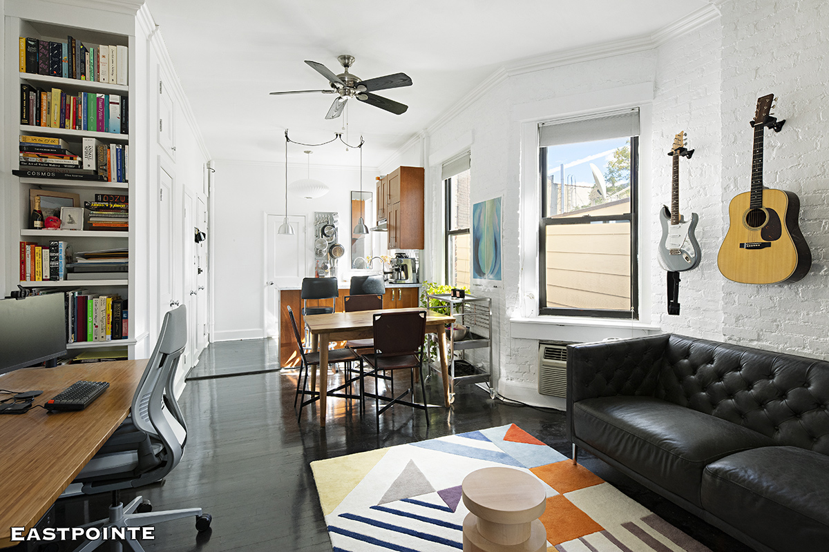 a living room with furniture a rug and a bookshelf