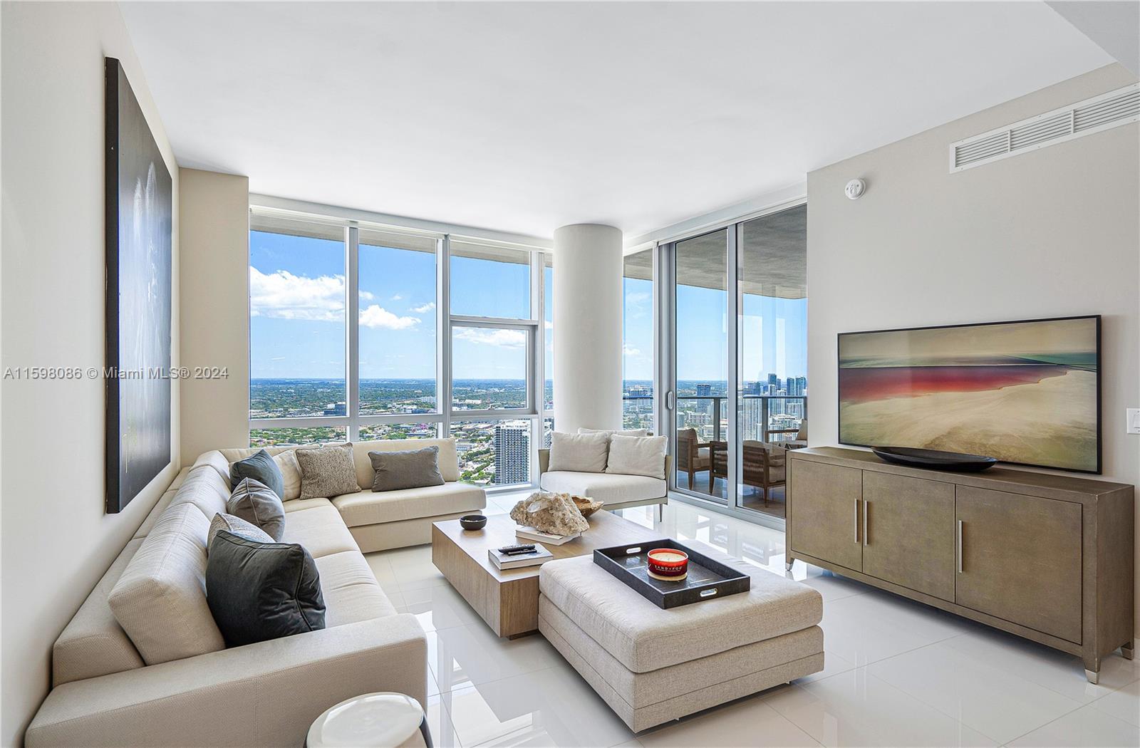 a living room with furniture a large window and a flat screen tv