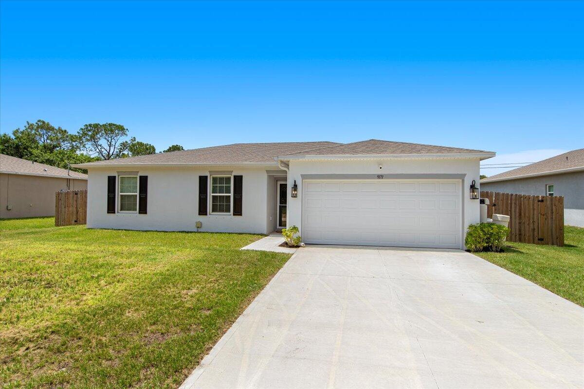 front view of a house with a yard and garage